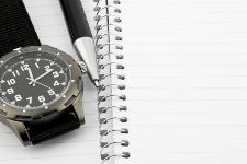 Pen and watch on notebook with room for text