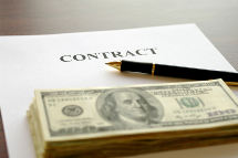 Contract page with pen and stack of dollars on table